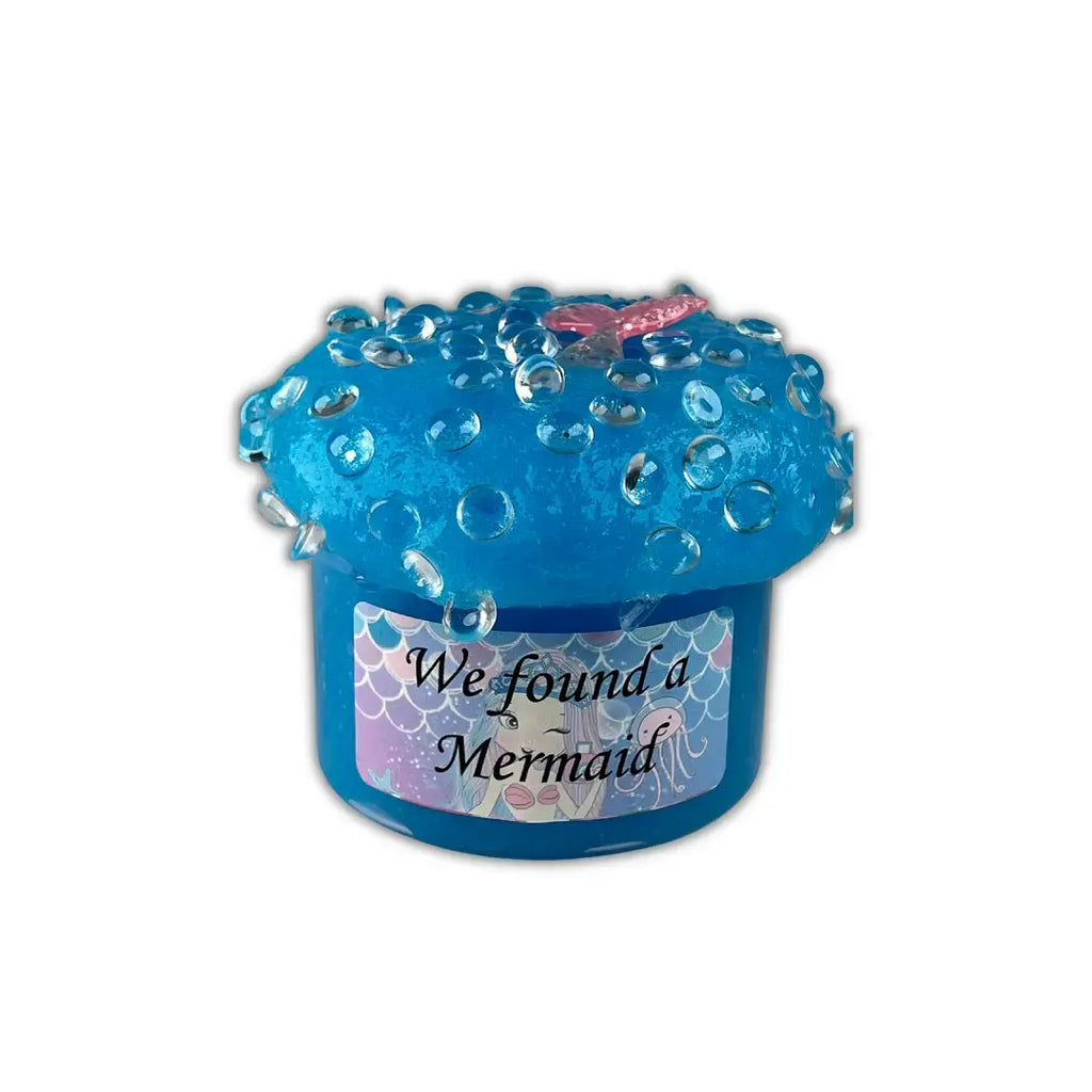 Handmade clear glue blue color jelly slime in a container topped with fish bowl beads